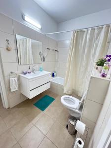 a bathroom with a toilet and a sink and a tub at The Shining Star -A beautiful 3 bedroom apartment in Beer Sheva +33 photos
