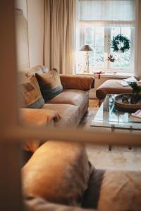 a living room with two couches and a window at Hiidhüüs Wenningstedt unter Reet mit Sauna in Wenningstedt