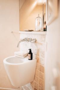 a bathroom with a sink with a soap bottle on it at Hiidhüüs Wenningstedt unter Reet mit Sauna in Wenningstedt