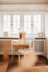 a table and chairs in a room with windows at Hiidhüüs Wenningstedt unter Reet mit Sauna in Wenningstedt +23 photos
