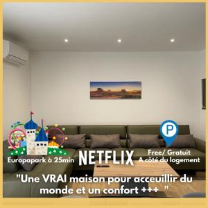 a living room with a couch and a picture on the wall at Europapark à 11km Maison Soleil climatisé in Friesenheim
