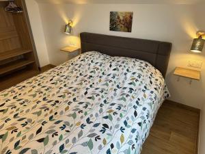 a bedroom with a bed with a bedspread on it at Europapark à 11km Maison Soleil climatisé in Friesenheim