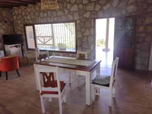 een eetkamer met een tafel en wat stoelen bij Cabaña de piedra Los Crespines in San Antonio de Arredondo