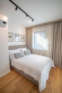 una camera da letto con un grande letto bianco e una finestra di Apartman Noovi - With private parking a Pola (Pula)