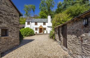 an external view of a white house with a driveway at Hedgehog Cottage Wheddon Cross in Wheddon Cross