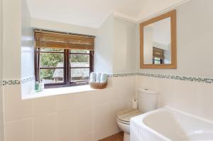 a bathroom with a toilet and a sink and a mirror at Hedgehog Cottage Wheddon Cross in Wheddon Cross +24 photos