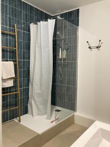 a bathroom with a shower with white shower curtain at Appartement d'architecte in Marseille