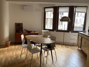 a dining room with a table and white chairs at Appartement d'architecte in Marseille