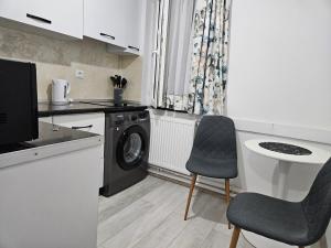 a kitchen with a washing machine and a dishwasher at Garsoniera in Râmnicu Vâlcea