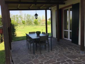a patio with a table and chairs on a patio at La Brentella in Arzergrande