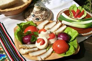 a plate of food with vegetables on a table at Pensiunea La Gorgan in Vadu Izei
