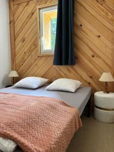 a bedroom with a bed and a window at Cottages des Pins in Saint-Hilaire-de-Riez +76 photos