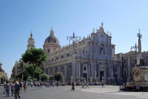 un grande edificio con persone che camminano davanti ad esso di Tra L'Etna E Il Mare B&B a Catania