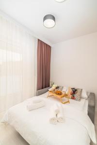 biała sypialnia z dużym białym łóżkiem ze stołem w obiekcie Prądnik Czerwony Studio - Balcony, City View - by Rentujemy w Krakowie