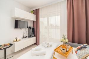 salon z białą kanapą i telewizorem w obiekcie Prądnik Czerwony Studio - Balcony, City View - by Rentujemy w Krakowie