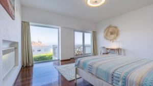 una camera da letto con un letto e una grande finestra di Estoril Oceanview Villa a Parede Altre 55 foto