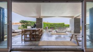 una porta di vetro di un patio con tavolo e sedie di Estoril Oceanview Villa a Parede