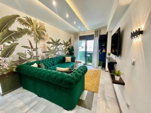 a green couch in a living room with plants at Jungle Vibes Stay - 2 BR Beach Front & Balcony in Tangier