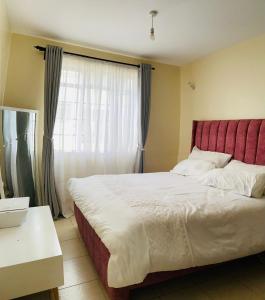 a bedroom with a large bed and a window at Beautiful 2 bedroom Furnished Apartment in Tatu City