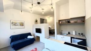 a living room with a blue couch and a kitchen at LAC Holiday Apartment in Calceranica al Lago