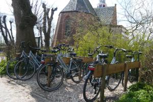 eine Gruppe Fahrräder, die neben einem Zaun geparkt sind in der Unterkunft Dorpslogement Pieterburen in Pieterburen