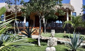a house with a garden with statues in front of it at Reset Atemporal in Homún