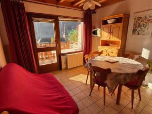 eine Küche mit Tisch und Stühlen in einem Zimmer in der Unterkunft Appartement 2 chambres avec balcon exposé Sud, parking et navettes à proximité - FR-1-692-39 in La Chapelle-dʼAbondance + 3 Fotos