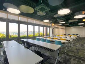 a classroom with tables and chairs and large windows at Upper Hotel Suites KL Sentral in Kuala Lumpur