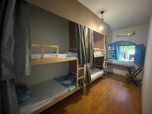 a room with two bunk beds and a window at HOSTEL ARACAJU Sequência Surf Paradise POUSADA in Aracaju