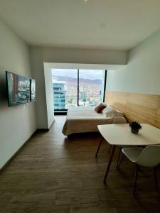 a bedroom with a bed and a table and a view at PRO HOME Balmaceda III in Antofagasta