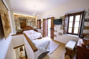 a bedroom with a bed and a stone wall at Apsinthium in Kalymnos
