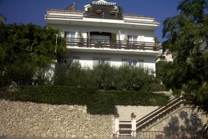 a white building with a balcony on top of a wall at Apartments Antoana in Hvar