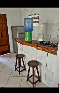 a kitchen with two stools and a bucket on a counter at BOIPEBA Cantinho do Mirko 1 in Cairu +10 photos