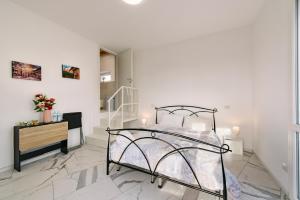 a white bedroom with a bed and a staircase at Villa Dei Sogni - Camera accesso indipendente Vicino Ospedale Borgo Trento Fiera Arena di Verona in Verona +18 photos