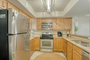 eine Küche mit Holzschränken und Geräten aus Edelstahl in der Unterkunft The Breakers 44 by Vacation Homes Collection in Orange Beach