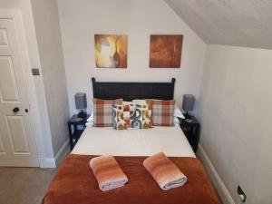 a bedroom with a bed with two pillows at St Leonards Guest House in Largs