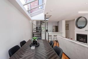 Un comedor con mesa y sillas y chimenea. en Re-Imagined Victorian Terrace Home, en Melbourne