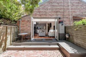 Habitación con jardín, patio y edificio de ladrillo en Re-Imagined Victorian Terrace Home, en Melbourne
