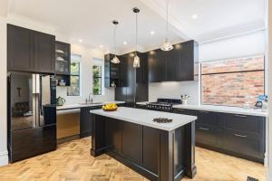 una cucina con armadi neri e ripiani bianchi di Beautiful Winchester Terrace Moonee Ponds a Melbourne