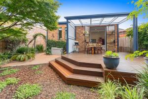 un cortile con terrazza con scale e una casa di Beautiful Winchester Terrace Moonee Ponds a Melbourne