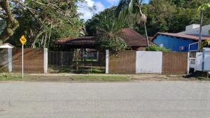 a brick house with a fence and a street at Casa Helena Barequeçaba in São Sebastião