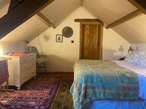 Un dormitorio con una cama y una cómoda en un ático. en The Coach House, The Old Rectory, en Barnstaple