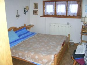 a bedroom with a bed with blue sheets at Mansarda Jouvenceaux in Sauze dʼOulx