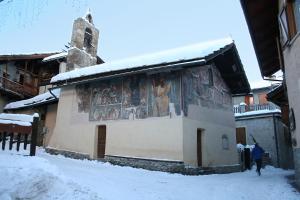 a building with a painting on the side of it in the snow at Mansarda Jouvenceaux in Sauze dʼOulx
