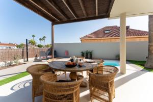 a patio with a table and chairs and a pool at Vivelorural Villa Óscar, Maspalomas in San Bartolomé de Tirajana