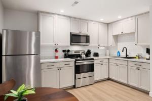 a kitchen with white cabinets and a stainless steel refrigerator at The Silo 2 - 1BD Stylish Comfort in Morton