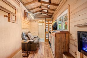 a living room with a couch in a tiny house at The Ritz Carlton of Tiny Cabins with Hot Tub in Elf