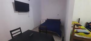 a room with a table and a bed and a television at Avenida Colon in Santiago del Estero