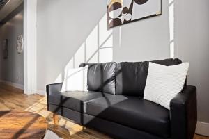 a black leather couch in a living room with a table at Chic Loft in Peoria Warehouse District in Peoria +39 photos