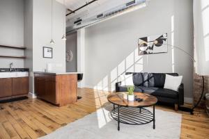 a living room with a couch and a table at Chic Loft in Peoria Warehouse District in Peoria